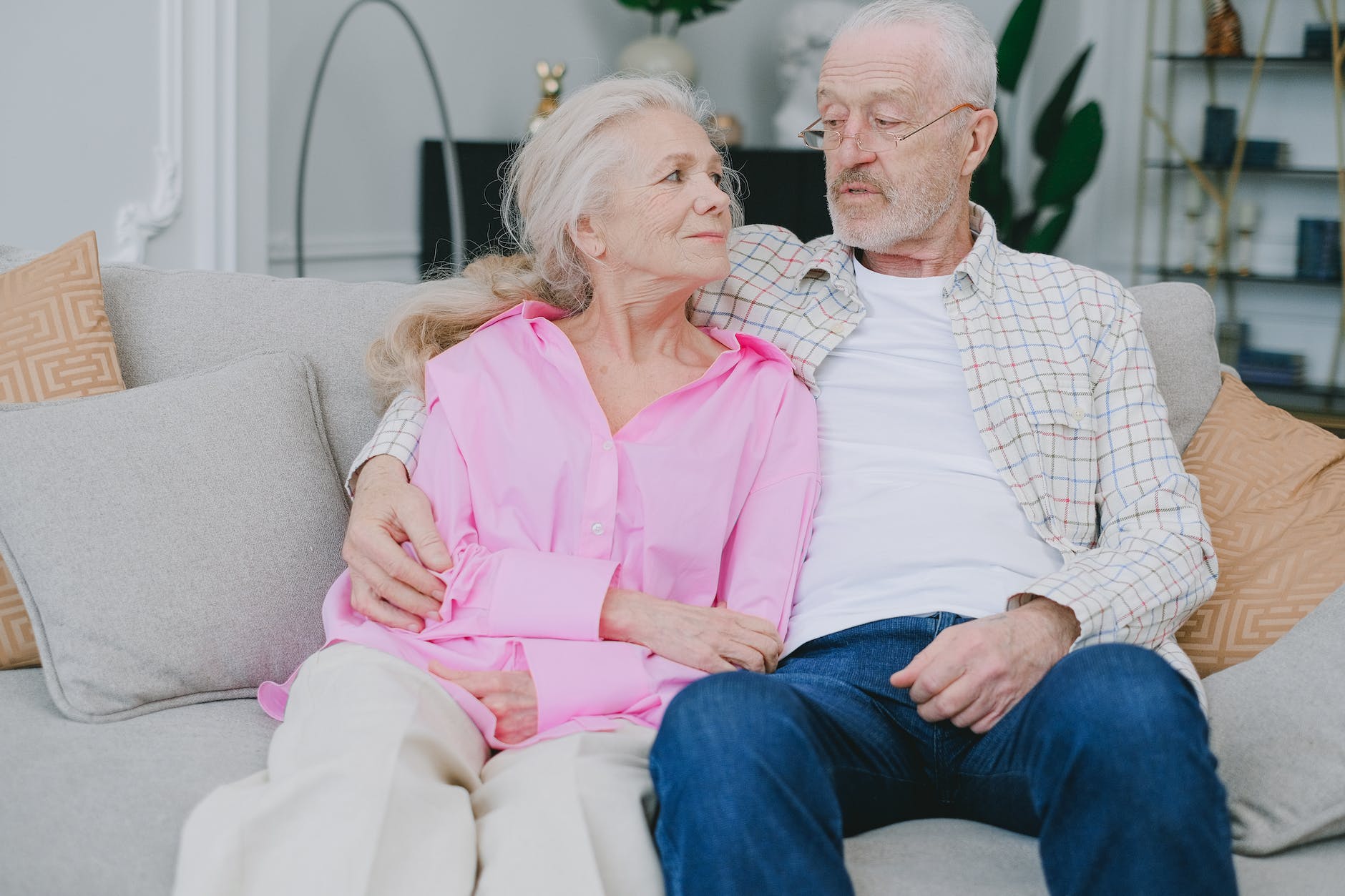 elderly couple sitting on sofa at home